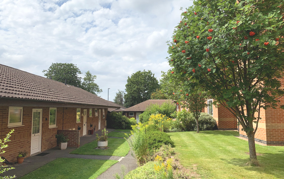 Garden path through sunny gardens at The Firs Complex