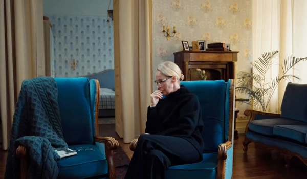Older Woman Sitting In Chair On Her Own
