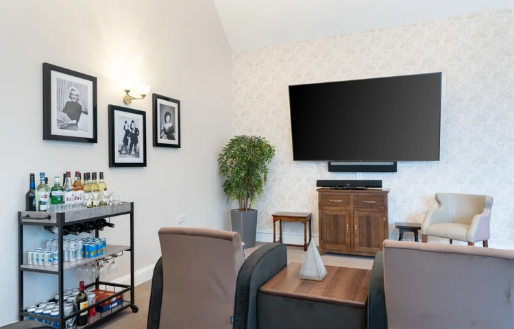 Large television, comfortable armchairs, and a well-stocked drinks trolley at Westall House Residential Care Home in Horsted Keynes.