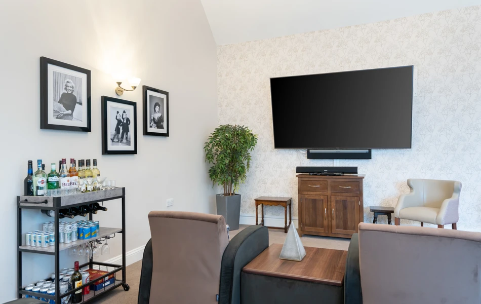 Large television, comfortable armchairs, and a well-stocked drinks trolley at Westall House Residential Care Home in Horsted Keynes.