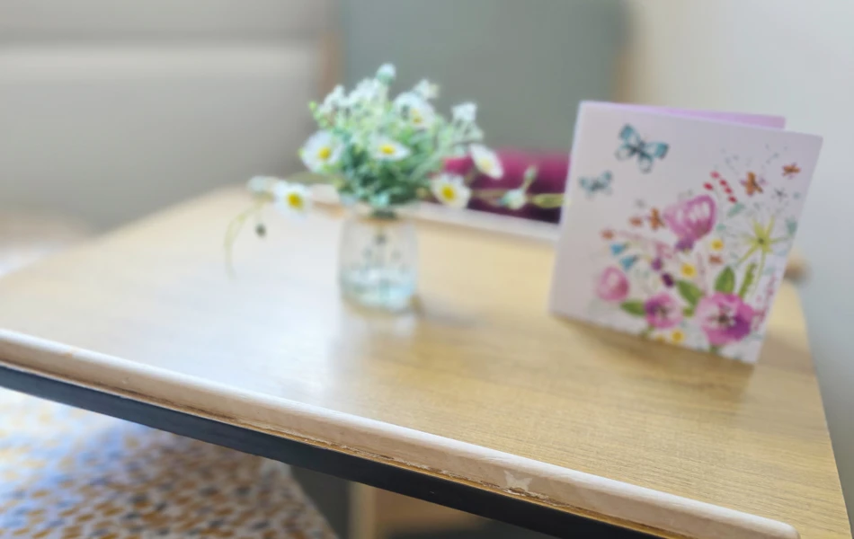 Card And Flowers On Over Bed Table In A Resident Room