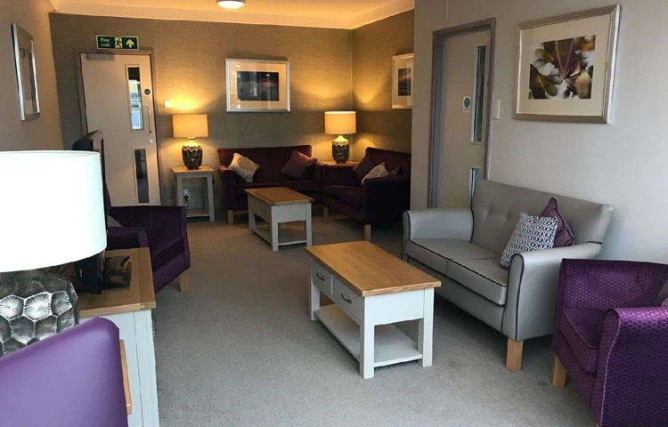 A modern lounge area with purple and grey chairs