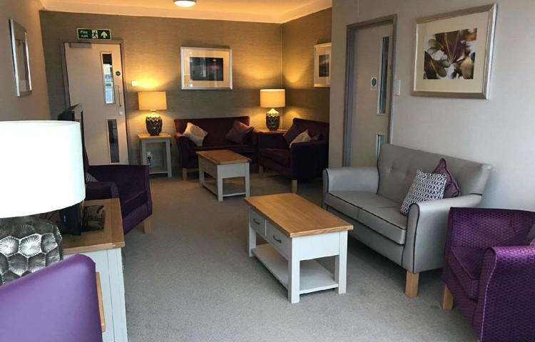 A modern lounge area with purple and grey chairs