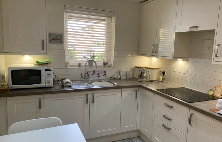 Internal view of a bright white modern kitchen at The Firs Complex