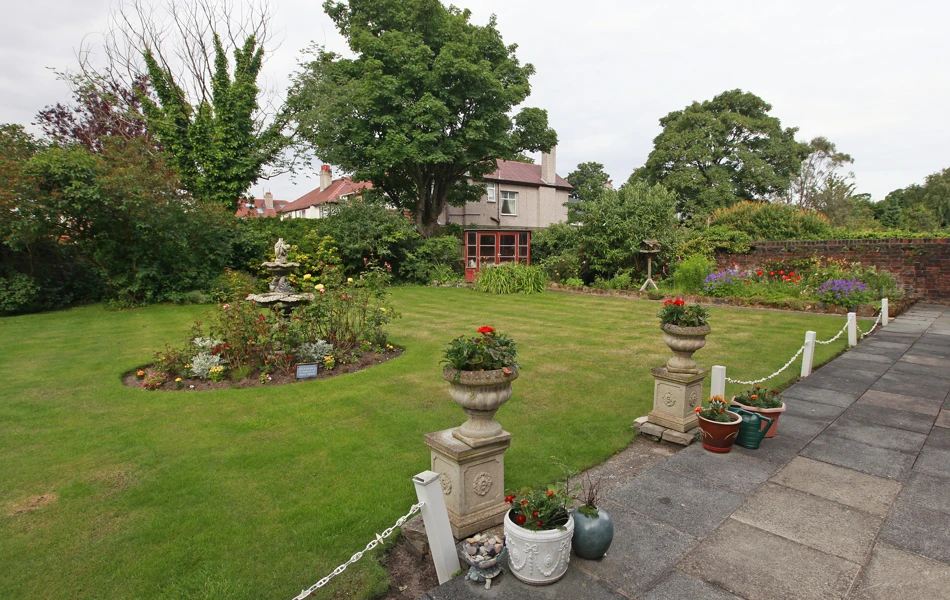A large garden with stone pillars and flowers