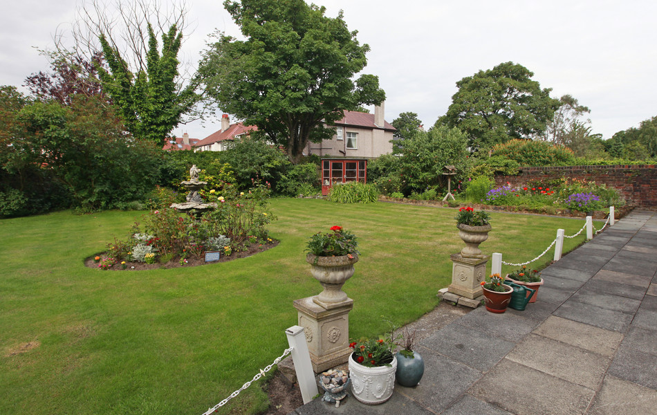 A large garden with stone pillars and flowers