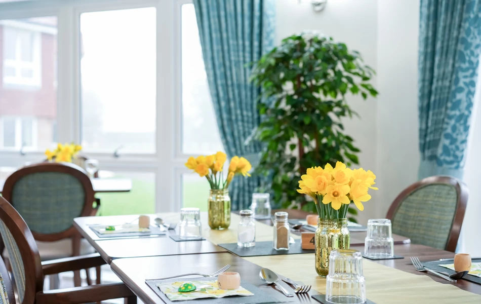 Bright and welcoming dining room at Westall House Residential Care Home in Horsted Keynes, featuring fresh flowers and plenty of natural light