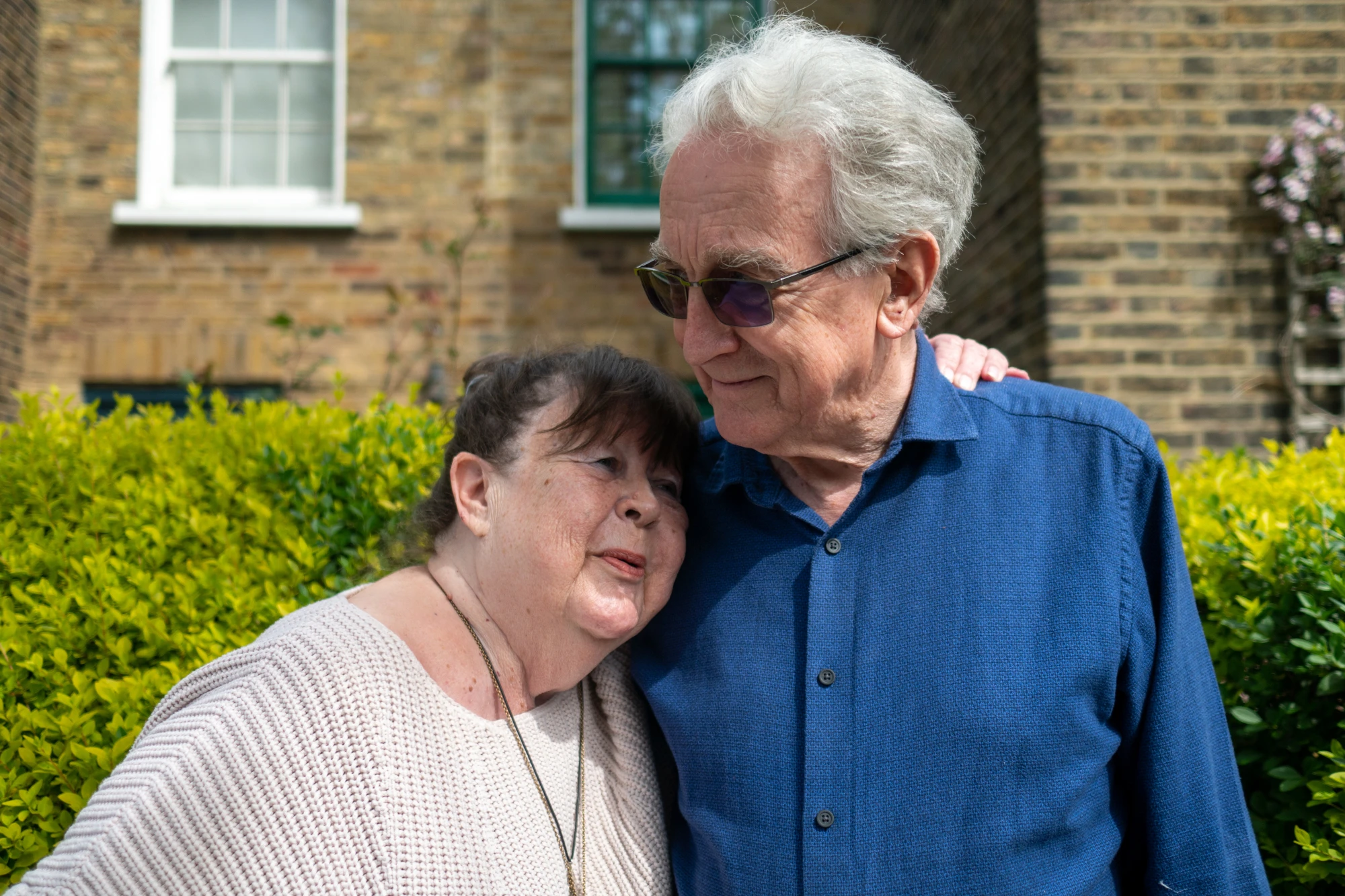 Happy older people laughing together outside in garden