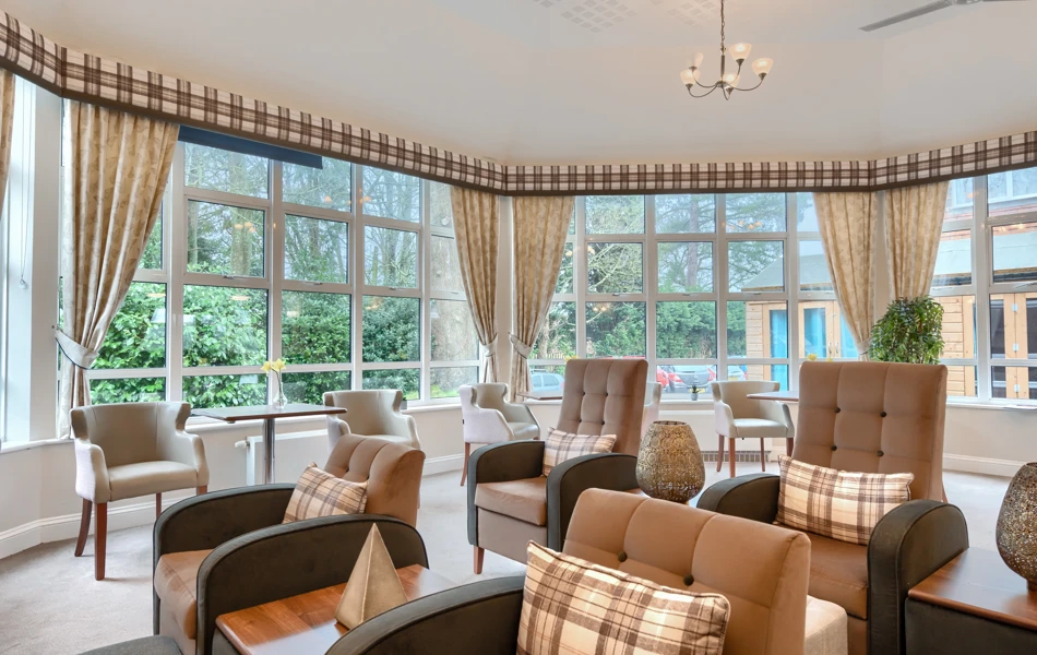 Spacious and bright sitting room at Westall House Residential Care Home in Horsted Keynes with comfortable armchairs and large windows overlooking gardens