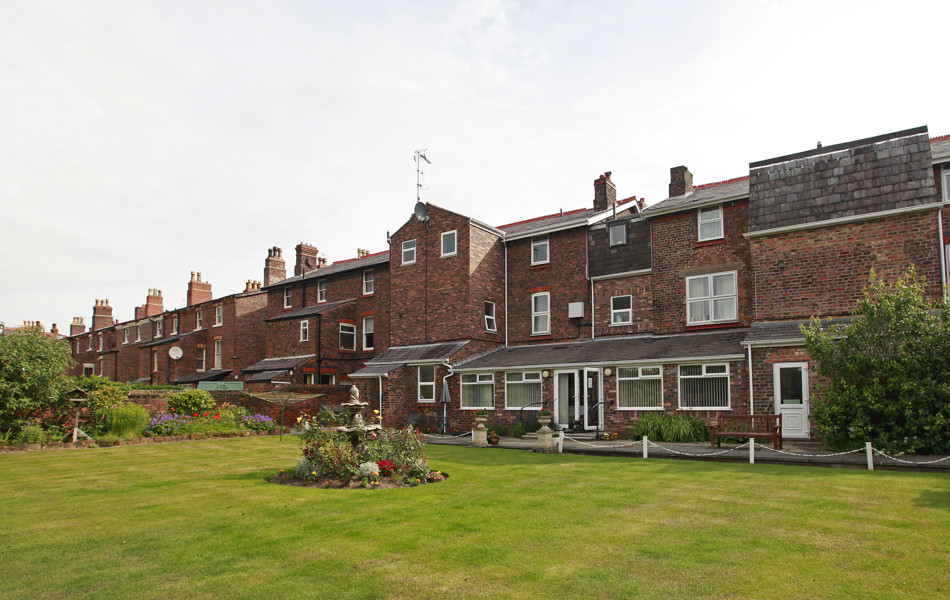 Large red brick house with garden and bird bath