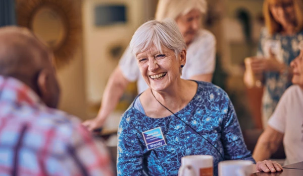 Smiling Older Woman Sitting With A Group Of Other People