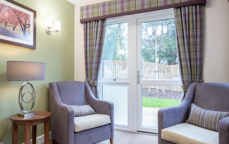 A cosy sitting area at Westall House with comfortable armchairs and a garden view