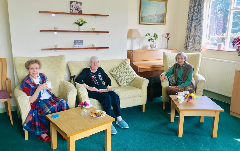 Residents enjoying tea and biscuits in the lounge