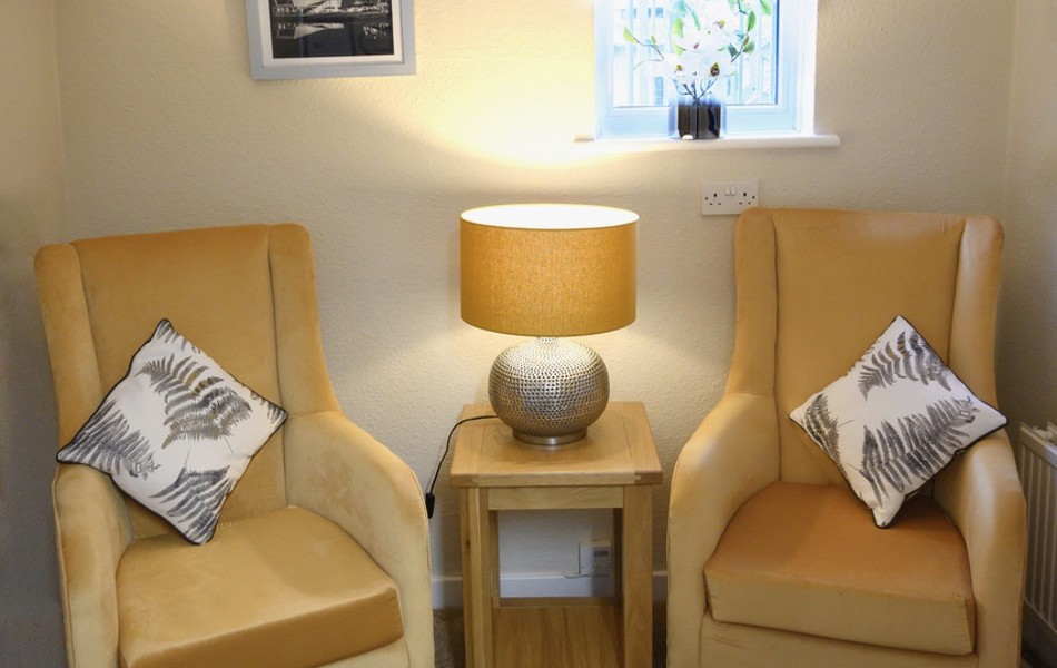 Snug area with two yellow chairs and a lit table lamp