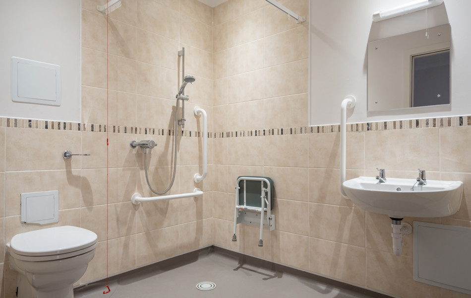 One of our assisted bathrooms with handrails and seating