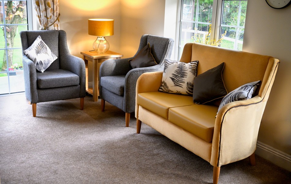 A modern lounge area with grey chairs and yellow sofa