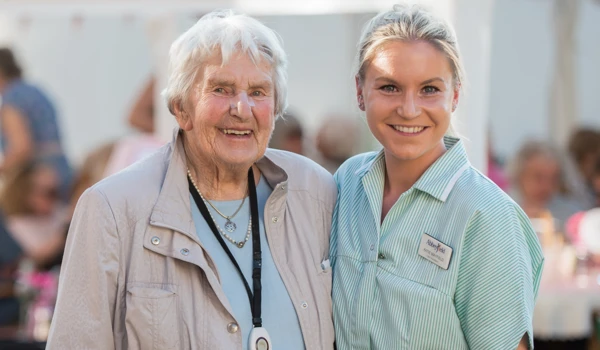 Resident And Carer Together At Garden Party
