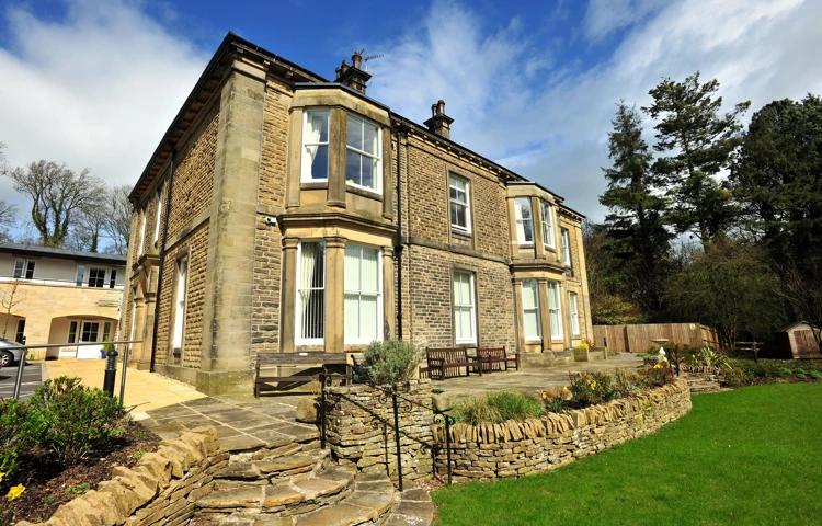 Woodlands a large stone house with stone wall and steps