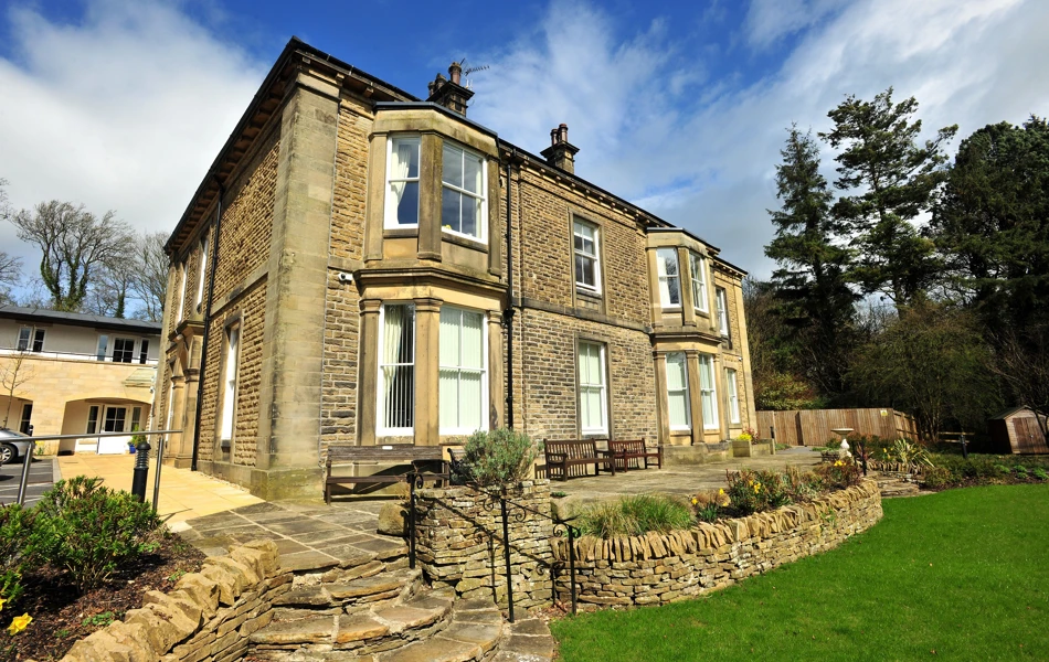 Woodlands a large stone house with stone wall and steps