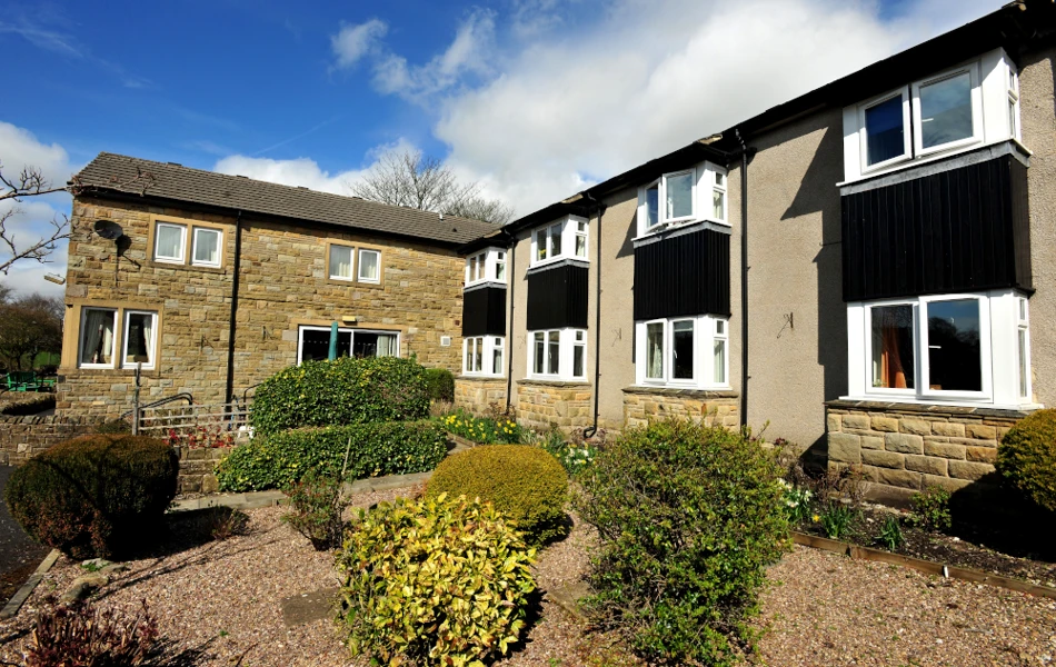 Garden area with shrubs under the house windows outside Abbeyfield House, Settle