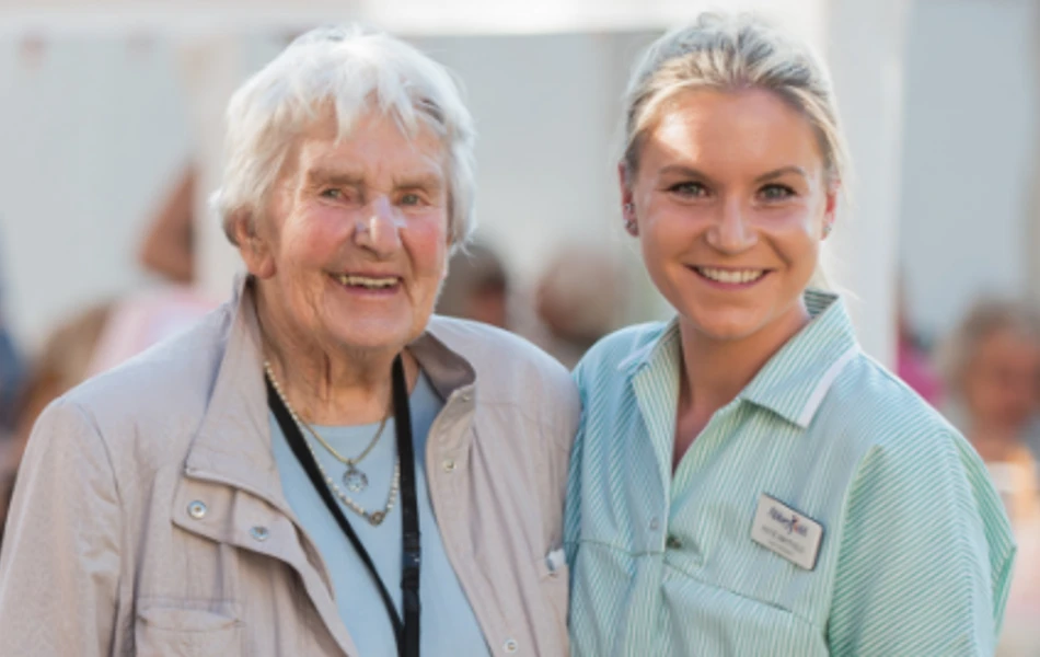 Smiling resident and staff member at Westall House event