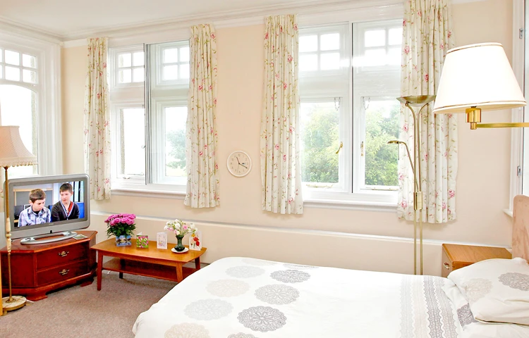 Bedroom with large windows at Abbeyfield Hill House
