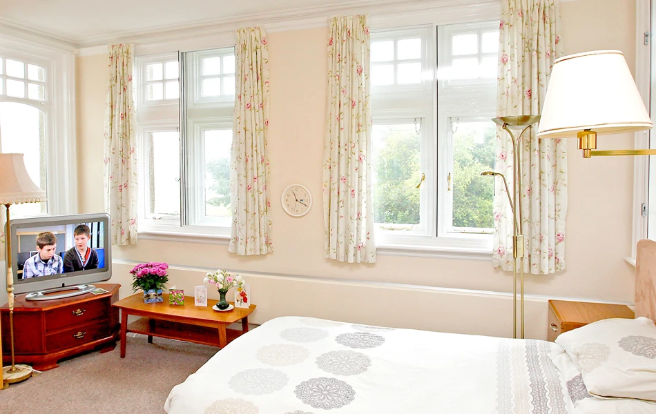 Bedroom with large windows at Abbeyfield Hill House