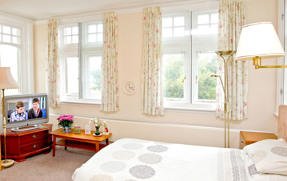 Bedroom with large windows at Abbeyfield Hill House