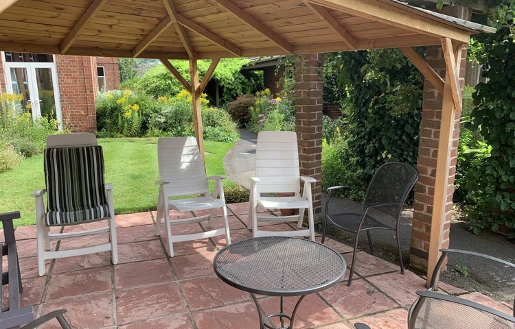 Abbeyfield Firs Complex garden showing wood and brick built gazebo with outdoor seating area